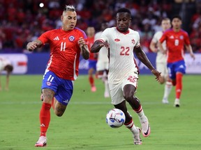Eduardo Vargas of Chile challenges for the ball with Richie Laryea of Canada during the CONMEBOL Copa America 2024 Group A match at Exploria Stadium in Orlando, Fla., Saturday, June 29, 2024.