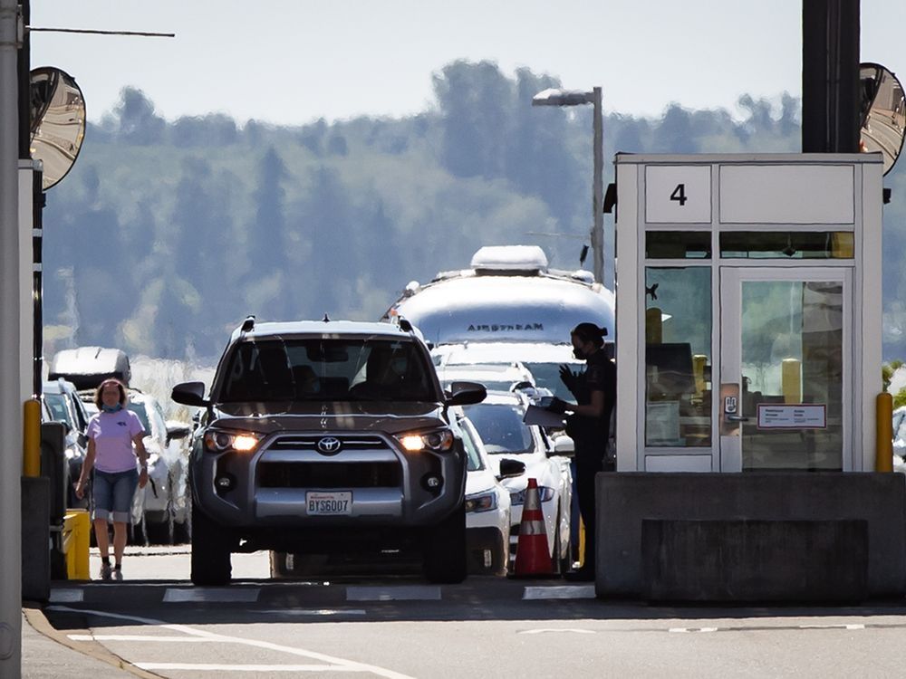 A Canada Border Services Agency officer speaks to a motorist entering Canada at the Douglas-Peace Arch border crossing, in Surrey, B.C., on Monday, August 9, 2021.