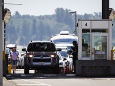 A Canada Border Services Agency officer speaks to a motorist entering Canada at the Douglas-Peace Arch border crossing, in Surrey, B.C., on Monday, August 9, 2021.
