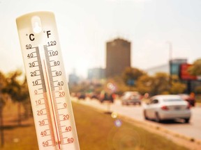 This file photo shows a thermometer in front of cars and traffic during heatwave in Montreal.