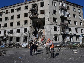 Rescuers and police officers work at the site of a destroyed residential building following an aerial bomb in the centre of Kharkiv, on June 22, 2024, amid the Russian invasion of Ukraine.