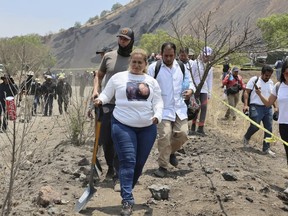 Ceci Flores, leader of a "searching mothers" group from northern Mexico, carries a shovel at the site where she said her team found a clandestine crematorium in Tlahuac, on the edge of Mexico City, May 1, 2024.
