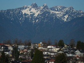Houses are seen on a hill in Vancouver, with the North Shore Mountains in the distance, on Thursday, Nov. 23, 2023.