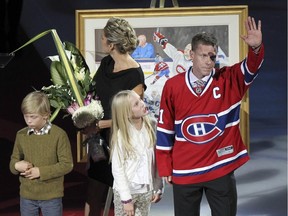 Former Canadiens captain Saku Koivu, with son Aatos, wife Hanna and daughter Ilona acknowledges ovation from fans during ceremony prior to National Hockey League game between the Habs and the Anaheim Ducks in Montreal on Dec. 18, 2014.