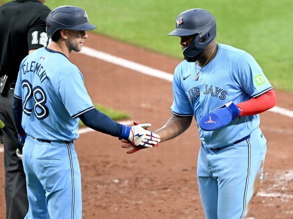 Vladimir Guerrero Jr. of the Toronto Blue Jays (right) celebrates scoring with Ernie Clement in the fourth inning against the Baltimore Orioles at Oriole Park at Camden Yards on July 30, 2024 in Baltimore, Md.