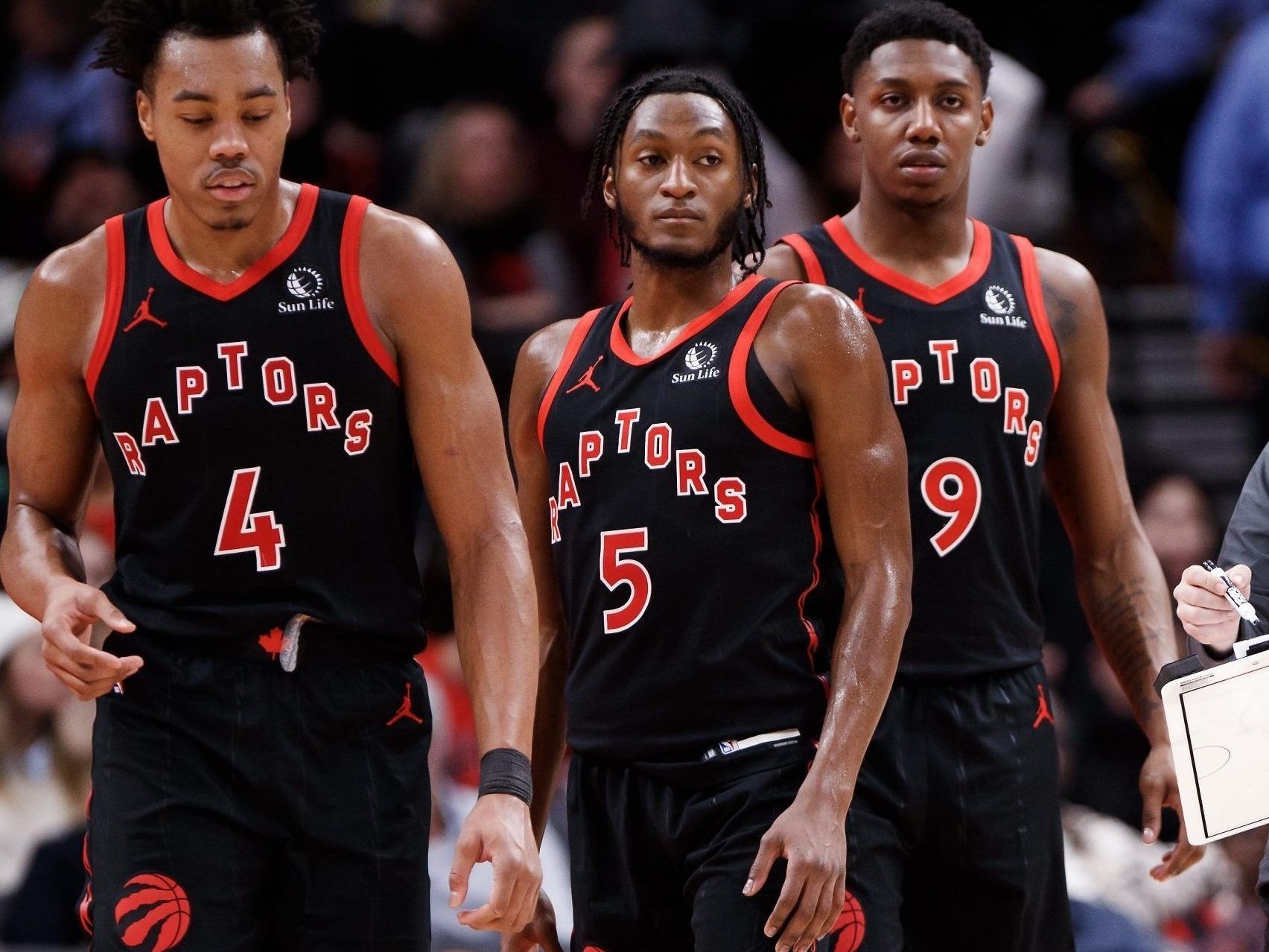 Scottie Barnes (4), Immanuel Quickley (5) and RJ Barrett (9) listen in during the second half of their NBA game against the Boston Celtics at Scotiabank Arena on Jan. 15, 2024, in Toronto.