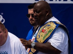 Eric "Badlands" Booker consoles a participant who threw up after competing in a lemonade-drinking contest at the Nathan's Famous Hot Dog Eating Contest on Thursday, July 4, 2024, in New York City.