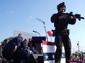 Republican presidential candidate former President Donald Trump is surrounded by U.S. Secret Service agents on stage at a campaign rally, Saturday, July 13, 2024, in Butler, Pa.
