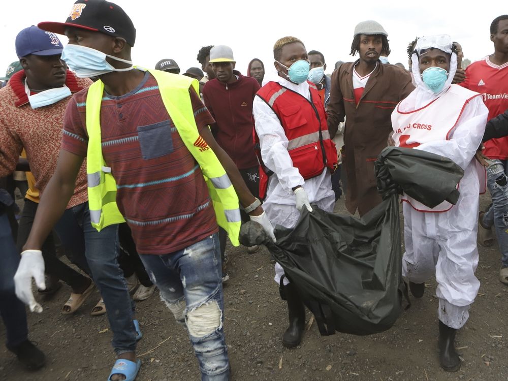 Rescuers carry sacks with human remains after being removed from a quarry in Mukuru Kwa Njenga area in Nairobi, Kenya Saturday, July 13, 2024.
