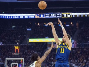 FILE - Golden State Warriors guard Klay Thompson (11) shoots a 3-point basket over Utah Jazz guard Collin Sexton, left, during the first half of an NBA basketball game April 7, 2024, in San Francisco. Thompson has been a pillar of the Warriors dynasty that won four NBA titles the past decade champions. Whether he will be part of the franchise as the team looks to rebound after missing the playoffs remains unknown.
