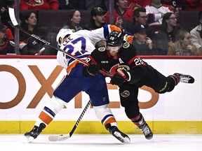 Ottawa Senators right winger Claude Giroux (28) tries to knock the puck away from New York Islanders left winger Anders Lee.
