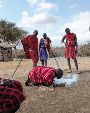 Watching men from a local Maasai village start a fire using cow dung and sticks.