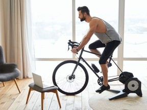 Handsome young man riding stationary exercise bike