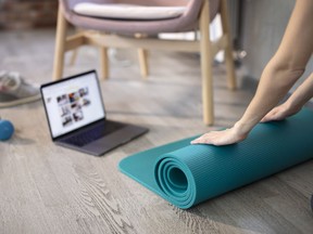 Preparing for training online. Mat, dumbbell, mat and laptop.