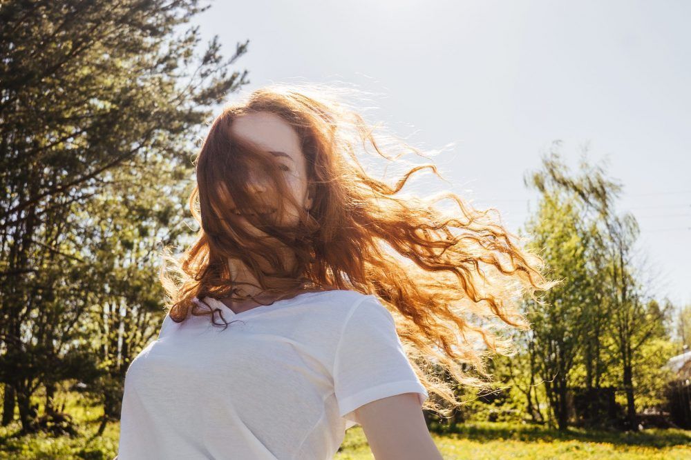Happy girl with long hair in sunshine.