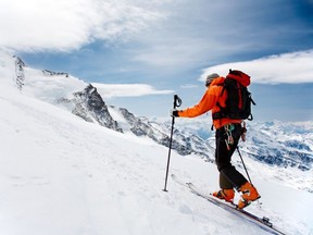 A man hiking in snowshoes up a snowy mountain