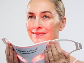 A woman putting on a LED face mask