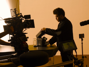 Tesfaye making a cup of coffee on a Nespresso machine.