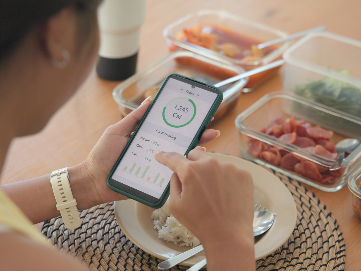 Young adult black asia people active gen z using AI phone record data daily meal tracker clean food diet app control. Asian Smart living care happy life goal routine plan lunch time home dining table.