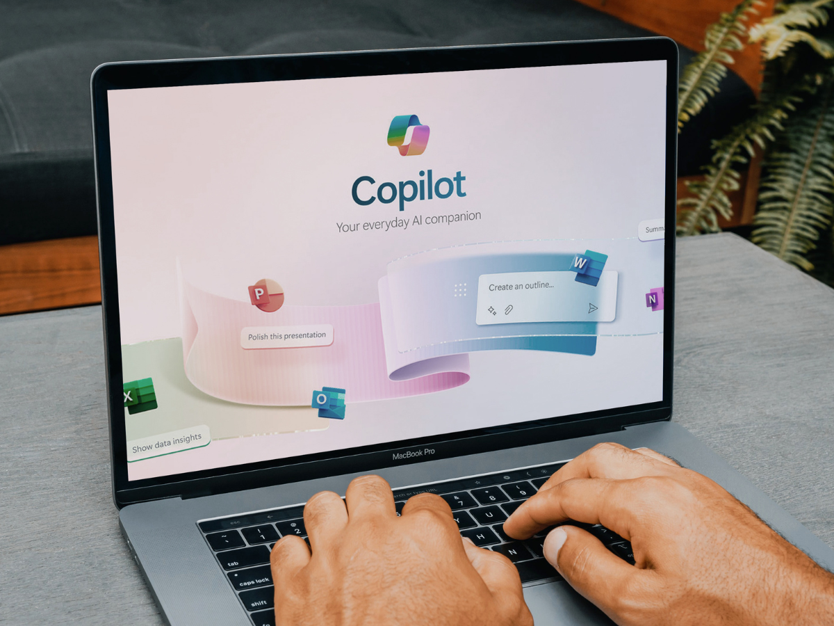 Office worker using copilot, microsoft's new ai companion, on a macbook pro