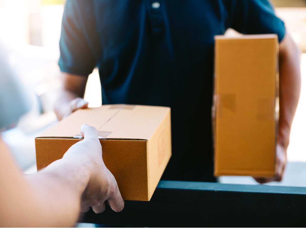 Close up of hands cargo staff are delivering cardboard boxes with parcels inside to the recipient's hand.
