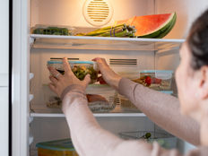Person organizing reusable glass meal prep containers.