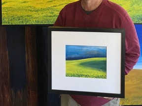 Grande Prairie artist, Carmen Haakstad, holds a recent small ‘painting sketch’ in front of Yellow Canola Field, his larger impression of a Peace Country canola field in full bloom. Both oil paintings will be on sale for the first time at his exhibit, The Seeker’s Journey Continues, at the Beaverlodge Art and Cultural Centre opening June 27.