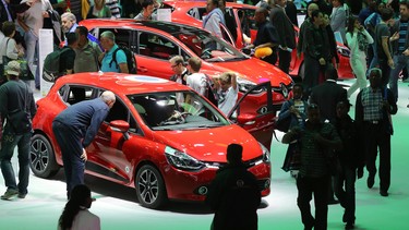 Visitors look at cars displayed on the stand of French auto maker Renault, during the opening day of the Paris Motor Show.