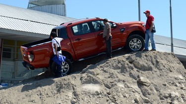 Visitors examine a 4x4 Ford ranger wildtrak displayed at a makeshift mound at the auto show.