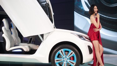 A model stands beside a 'Haval E' car by Chinese manufacturer Great Wall Motors, at the Auto China 2012 car show in Beijing on April 23, 2012. Beijing is hosting the Auto China 2012 exhiition in which top world carmakers will roll out a host of new models as they scramble for an edge amid sharply slowing sales in the planet's largest automobile market. The show runs until May 2. AFP PHOTO / Ed Jones (Photo credit should read Ed Jones/AFP/Getty Images)