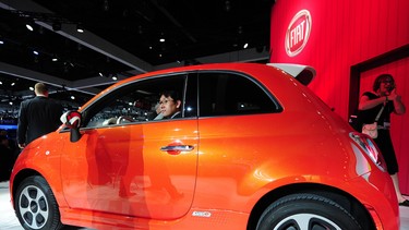 A visitor sits behind the wheel of the new  Fiat 500e electric car after it was unveiled at the Los Angeles Auto show in Los Angeles, California on media preview day, November 28, 2012.
