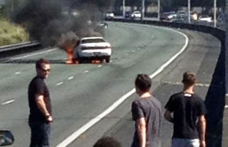 A car burns on a highway in Brisbane, Australia, moments after its driver went on a rampage and the fled the vehicle, sans clothes. (The Courier-Mail)
