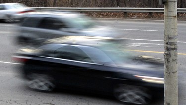 Cars go speeding by an intersection in this file photo.