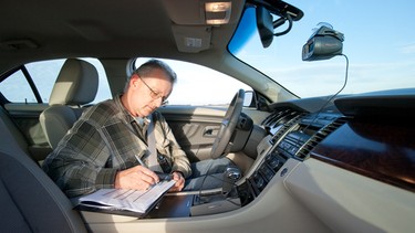 Journalist Jeremy Sinek noting results of performance measures conducted with one of the Car of the Year’s new GPS-based devices.