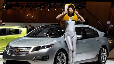 A model poses next to the Chevrolet Volt Plug-in-Hybrid car during the first press day at the 80th Geneva International Motor Show on March 2, 2010 in Geneva, Switzerland. The show features World and European premieres of cars and will be open to the public from March 4 to 14, 2010.