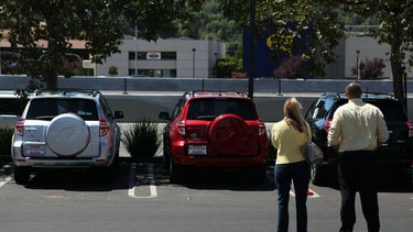 A woman looks at new Toyotas with a salesman in this file photo.