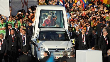 Pope Benedict XVI is surrounded by security guards in his pope mobile on arriving at Cibeles square during World Youth Day 2011 celebrations on August 18, 2011 in Madrid, Spain.