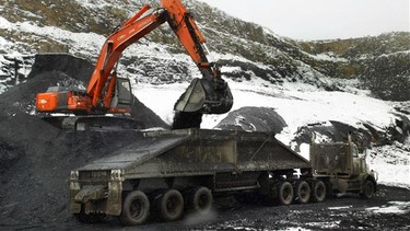 A power shovel loads a 25 tonne coal hauling truck at Grande Cache Coal's open pit mine above the tree line, 2020 metres above sea level.