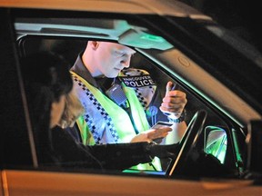 Police officers conduct a roadblock checking for impaired drivers in this file photo.