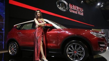 A model poses with a Great Wall H7 SUV at the Shanghai International Automobile Industry Exhibition (AUTO Shanghai) media day in Shanghai.