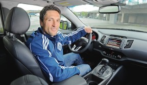 Vancouver Whitecaps player John Thorrington behind the wheel of a 2012 Kia Sportage outside BC Place. The crossover features a turbocharged 4-cylinder engine mated to a 6-speed manumatic transmission. This vehicle also features (below, left to right) a chunky sport steering wheel, attractive 18-inch alloy wheels and a two-panel panoramic sunroof.