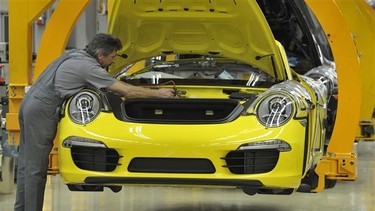 An employee of German luxury car maker Porsche working on the Porsche 911 sportcar assembly line at their plant in Stuttgart, southwestern Germany.