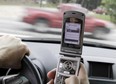 HOLD FOR RELEASE AT 12:01 A.M. EDT AND THEREAFTER ON THURSDAY, AUG. 22, 2013 - FILE - In this Sept. 20, 2011 file photo, a phone is held in a car in Brunswick, Maine. Americans are significantly less worried about drunk, aggressive and drowsy driving than they were four years ago even though traffic deaths have begun to edge back up, according to a survey by the AAA Foundation for Traffic Safety. At the same time, most Americans consider texting while driving completely unacceptable behavior, al