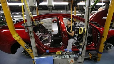 A Mazda employee works on the assembly line of the Mazda6 (Atenza) model at its plant in Hofu, Yamaguchi prefecture, southwestern Japan, Tuesday, Aug. 27, 2013. Mazda, the longtime also-ran of Japanese automakers, shows a new super-efficient plant that's rolling off vehicles at a stunning rate of one every 54 seconds. The plant is part of the reason why Mazda Motor Corp. has managed to defy skeptics who've predicted fates ranging from bankruptcy to a buyout by Chinese interests. (AP Photo/Shizuo