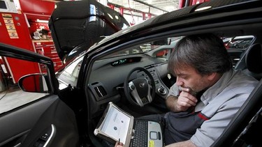 FILE - In this Feb. 9, 2010 file photo, master diagnostic technician Kurt Juergens, of Foxborough, Mass., uses a laptop computer to diagnose and repair the brake system on a 2010 Toyota Prius in the repair shop of a Toyota dealership, in Norwood, Mass. A pair of hackers maneuvered their way into the computer systems of a 2010 Toyota Prius and 2010 Ford Escape through a port used by mechanics. The hackers showed that they could slam on the brakes at freeway speeds, jerk the steering wheel or even