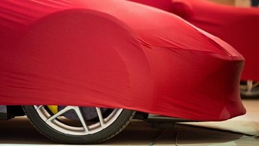 Veiled Ferrari cars wait on the grounds of the International Motor Show IAA in Frankfurt , Germany,Sunday Sept. 8, 2013. The 65th IAA features more than 1,000 exhibitors from around the world and takes place from Sept. 12 to Sept. 22 , 2013. (AP Photo/dpa,Boris Roessler)