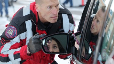 Calgary police Const. John Froese illustrates distracted driving with Henry Wise Wood grade 12 high school student Danica Josefchak during an event put on by the Calgary Police Services and Universal Ford at the school.