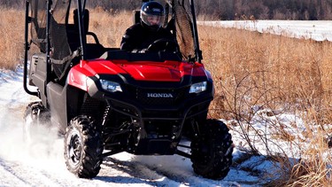 David Booth goes for a spirited ride in the snow in the 2014 Honda Pioneer side-by-side ATV.