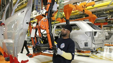 A Chrysler employee works on the assembly line making the new Jeep Grand Cherokee at the Chrysler Jefferson Avenue Plant in Detroit.