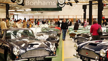 Buyers look at a line of of Aston Martin cars at the Aston Martin Works Service factory during an auction held by Bonham's on May 9, 2009 in Newport Pagnell, England. Vehicles at auction include a 1961 Aston Martin DB4 Series III,  estimated at £100,000, and a 1970 DB6 Vantage Volante worth a projected £350,000.
